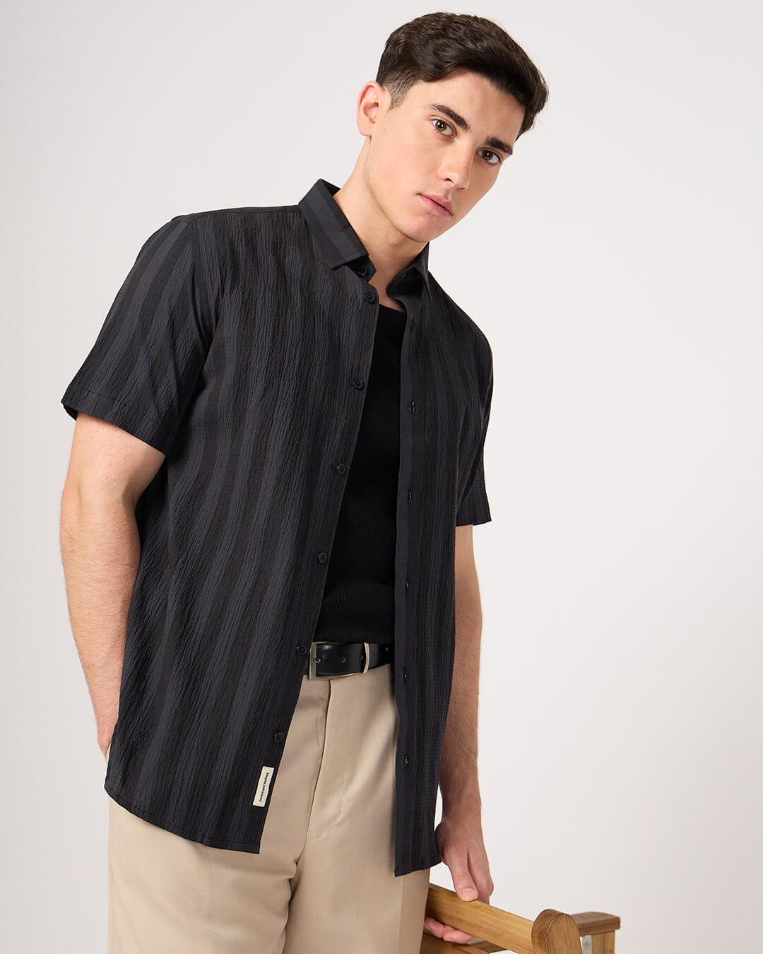 A man wearing a striped half sleeve shirt.