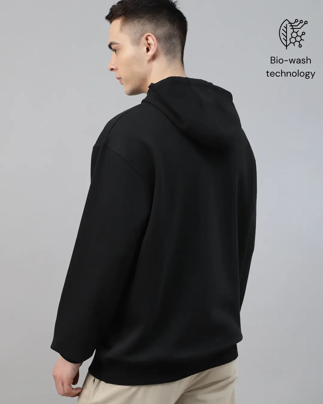 Person wearing a black hoodie made with 'Bio-wash fabric'