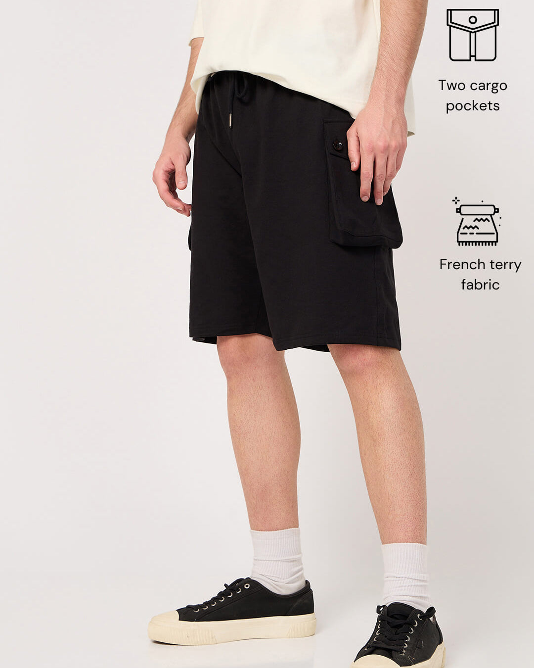 Person wearing black shorts with two cargo pockets on a white background