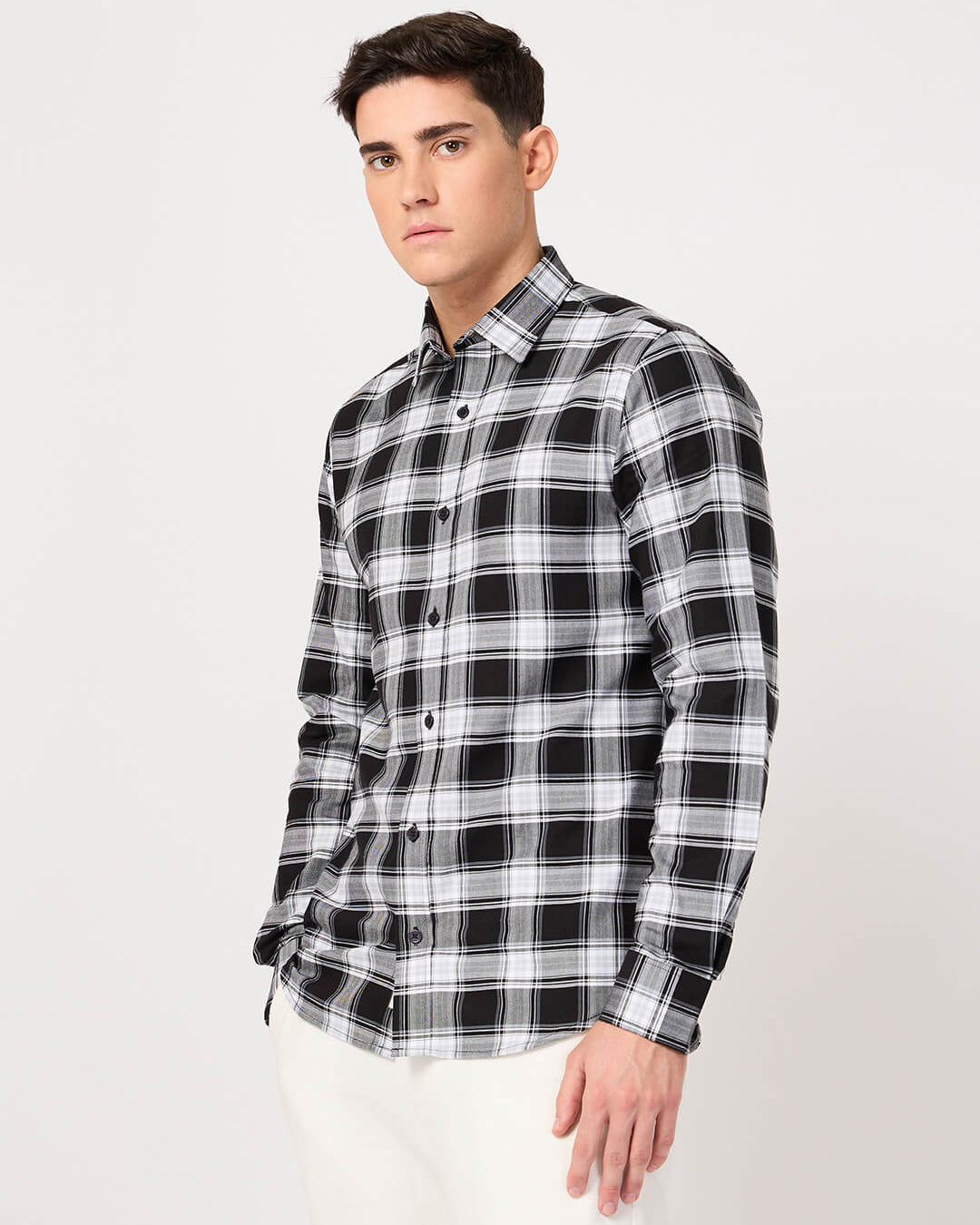 Man wearing a cotton black and white check shirt on a white background
