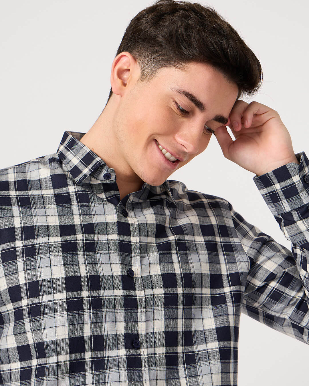Man wearing a plaid shirt against a plain background