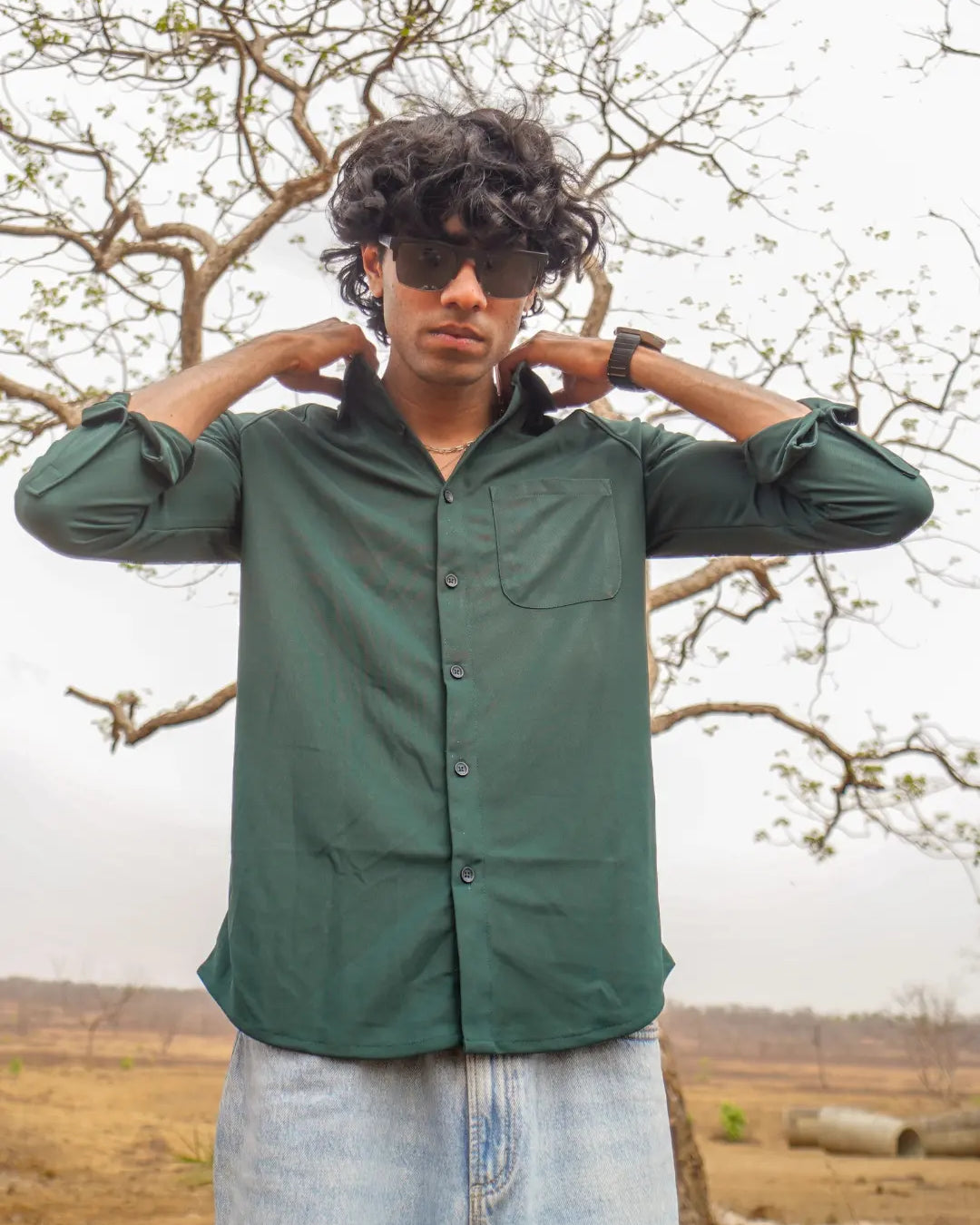 A man wearing a dark green long-sleeve button-up shirt