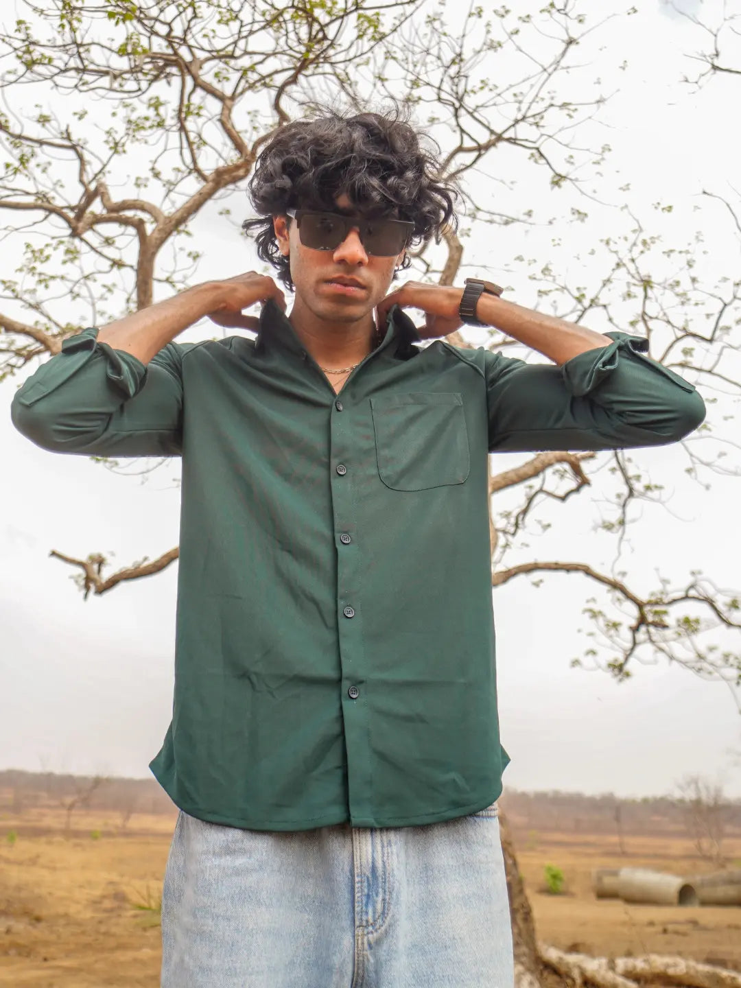 A man wearing a dark green long-sleeve button-up shirt