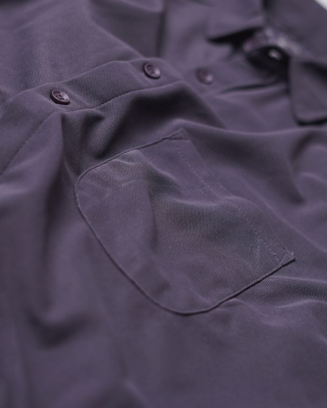Close-up of a dark purple shirt with buttons and a pocket