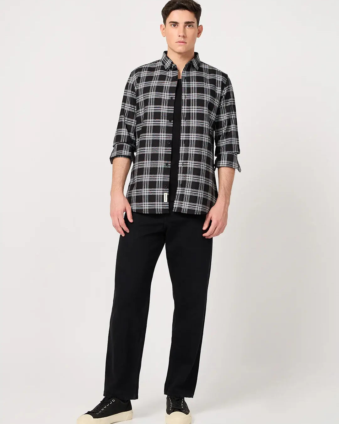 Man wearing a black and white checkered shirt and black pants