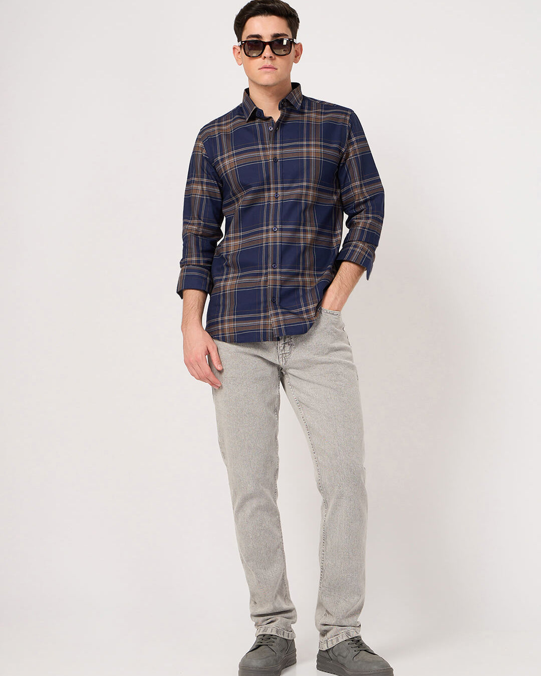 Man wearing blue brown check shirt shirt and gray pants