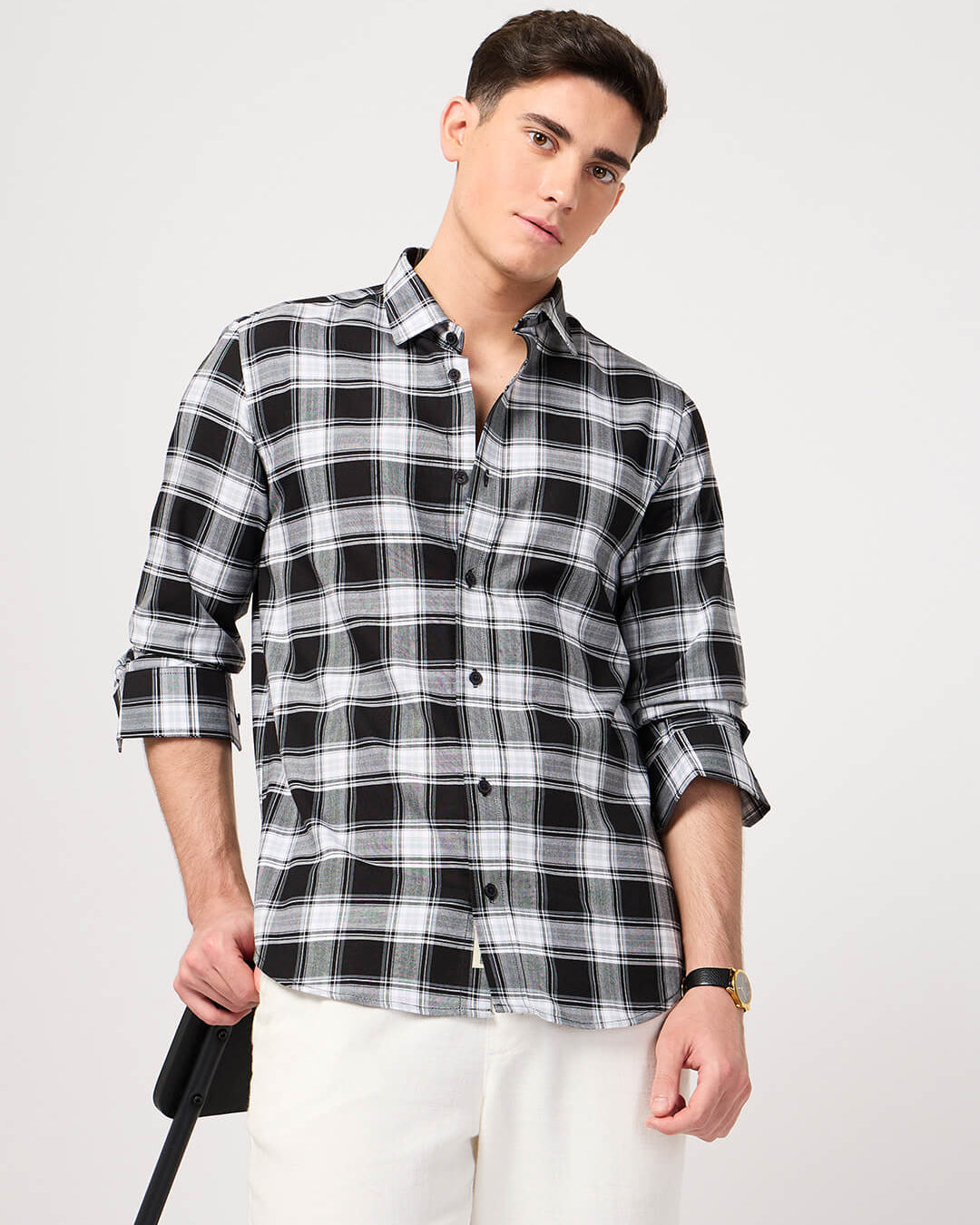 Man wearing a black and white plaid shirt on a plain background