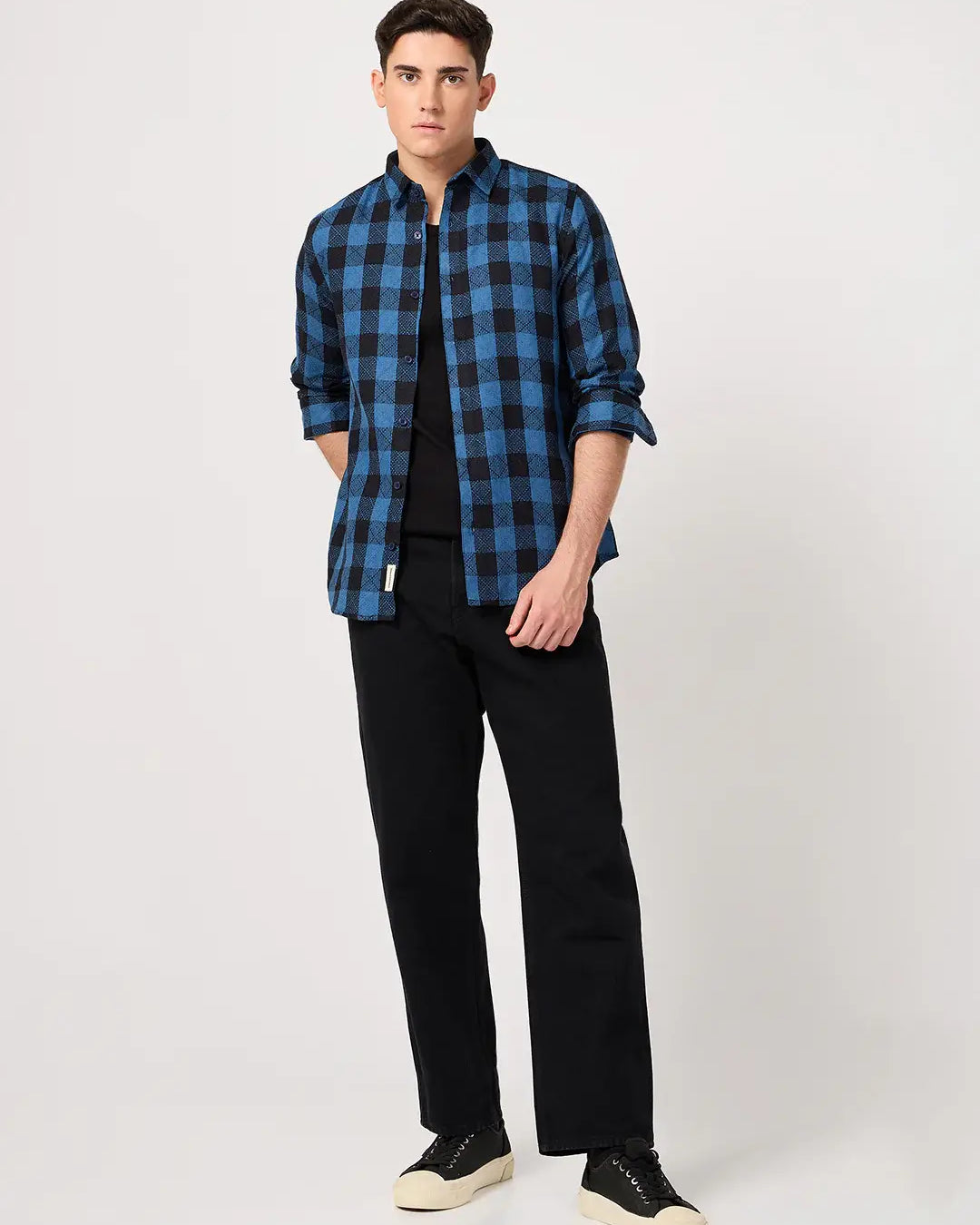 Man wearing a blue and black checkered shirt with black pants