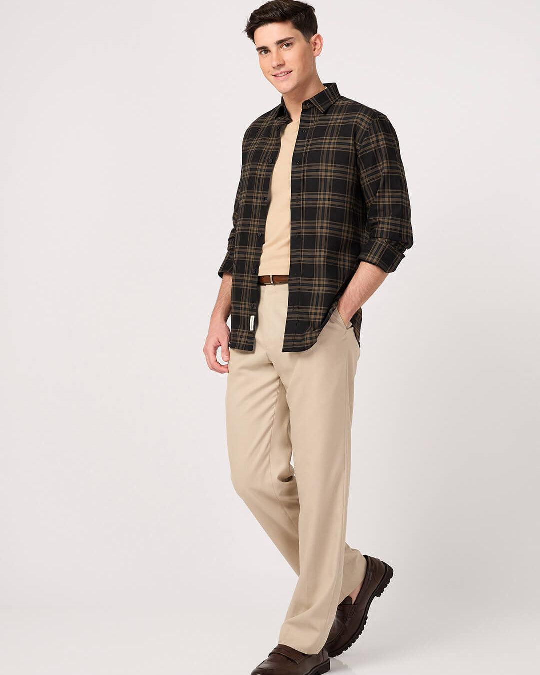 Man wearing a Oxford Cotton Brown Check Shirt, and beige pants on a white background