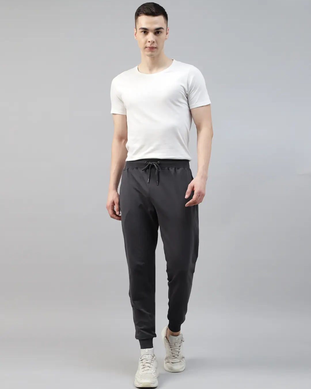 Man wearing a white t-shirt and dark gray jogger pants
