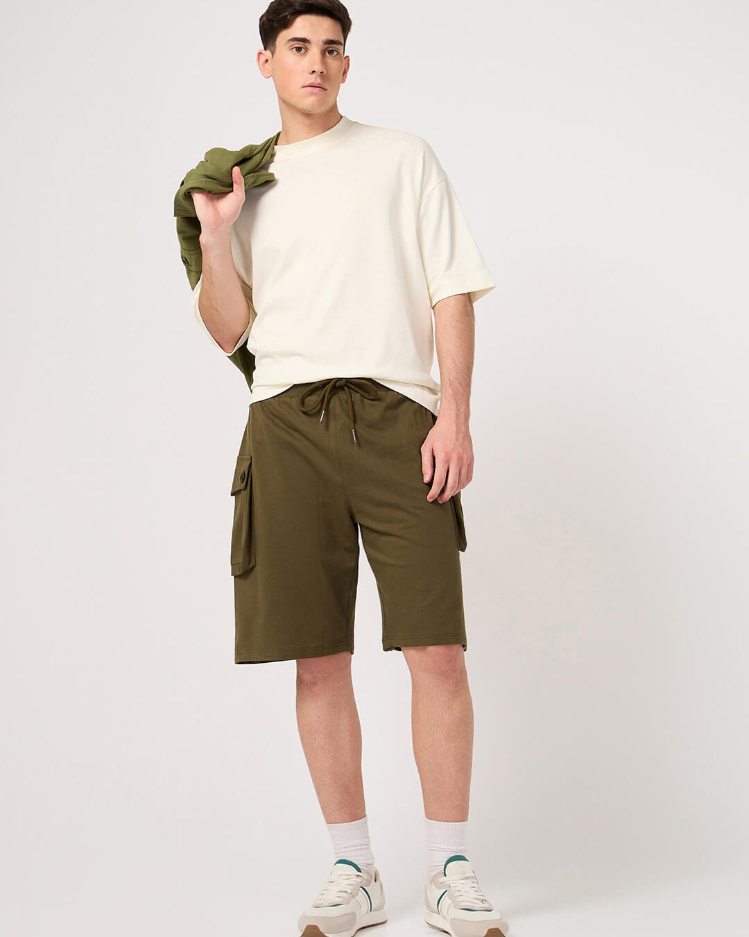 Man wearing a white t-shirt and olive cargo shorts on a white background