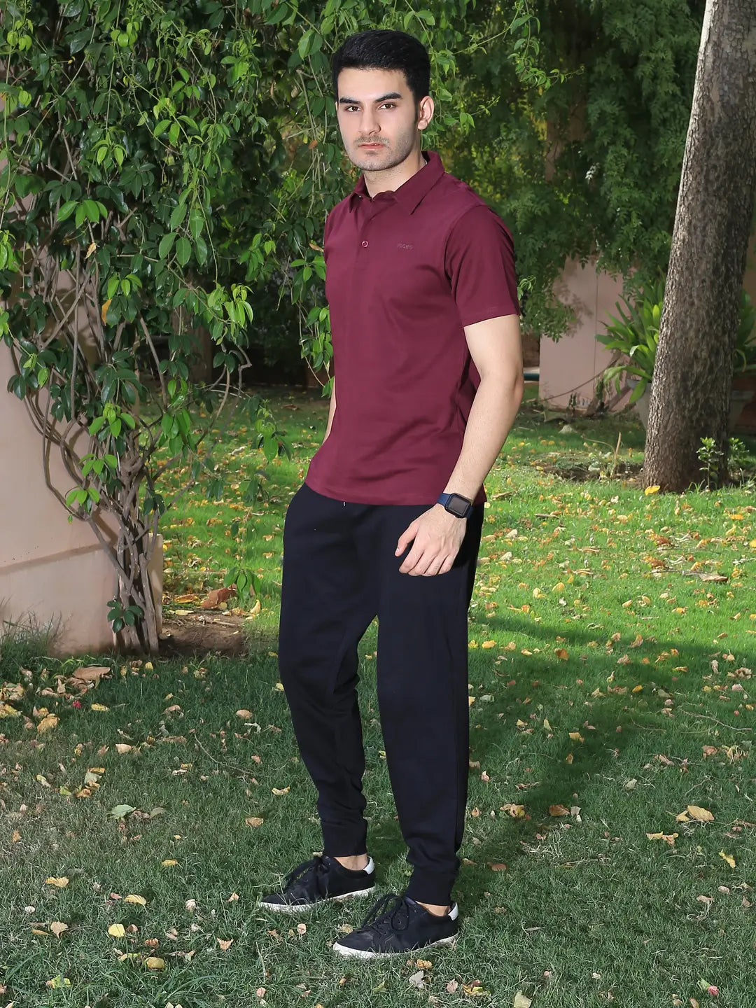 Man wearing a maroon polo shirt and black pants