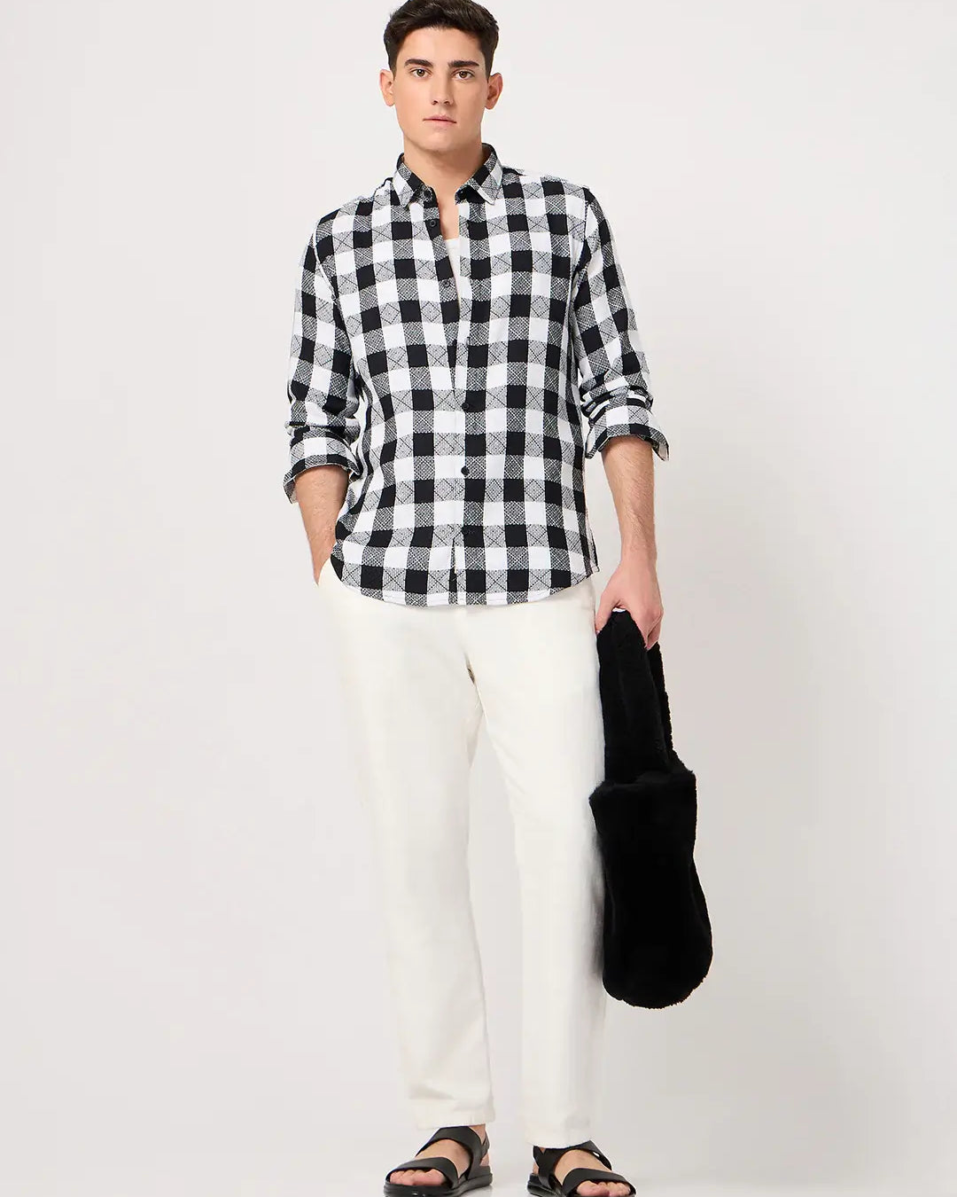 Man wearing a black and white checkered shirt and white pants