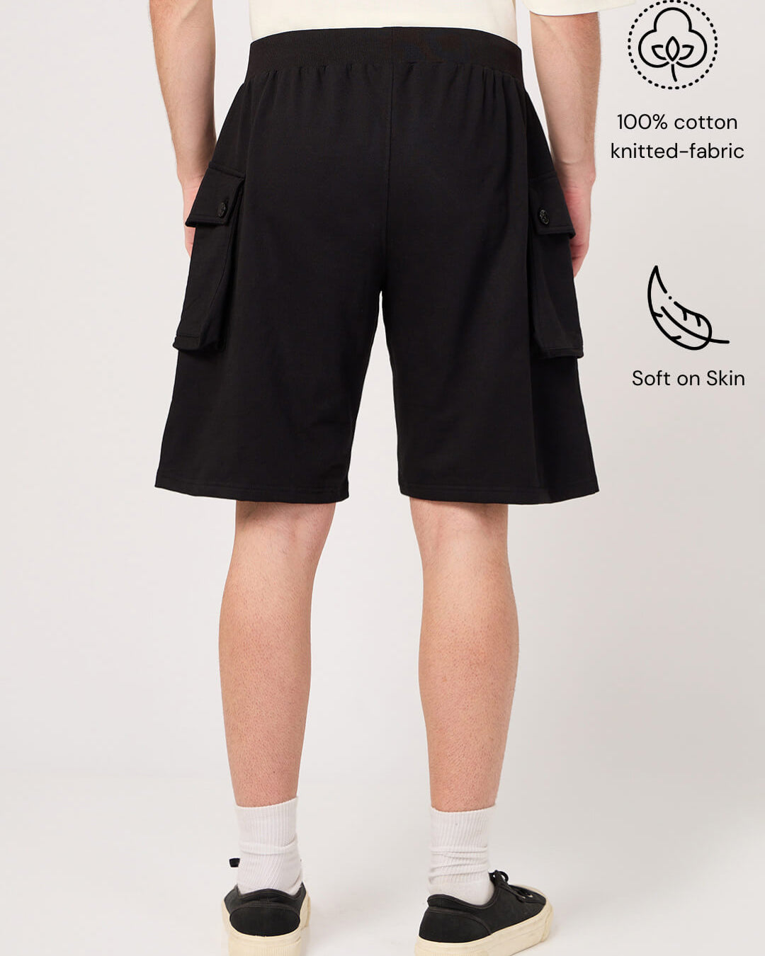 Person wearing black cargo shorts on a white background