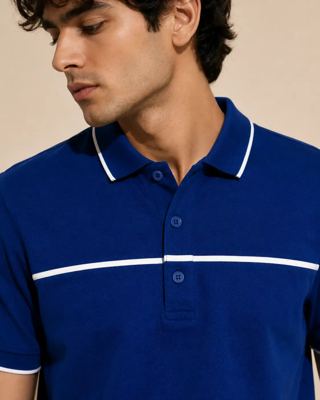 man wearing a royal blue polo shirt with white contrast piping
