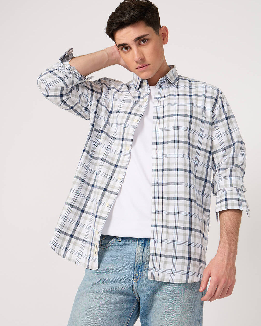 Man wearing a cotton check shirt over a white tshirt with light blue jeans