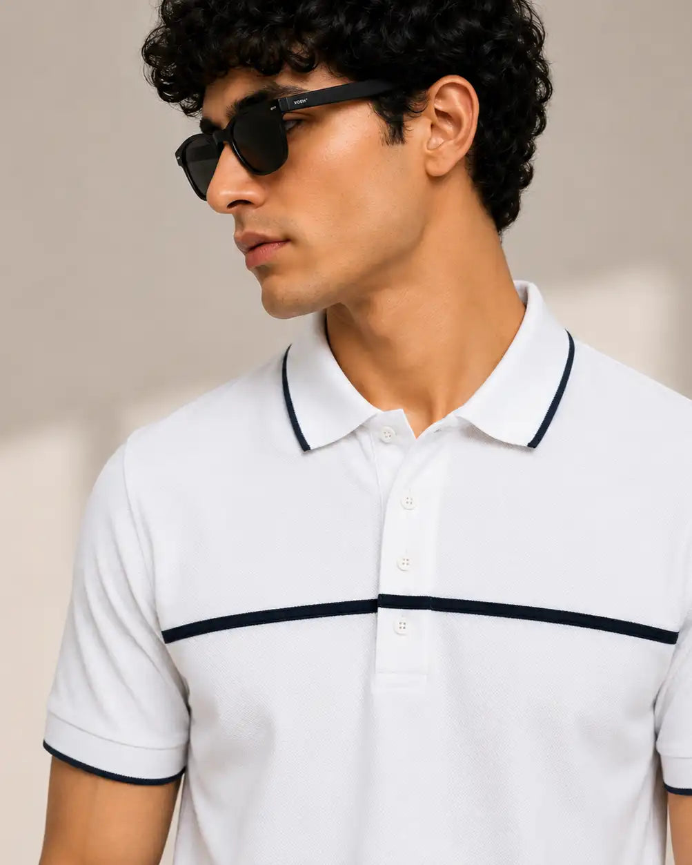 A man wearing a white short-sleeve polo shirt