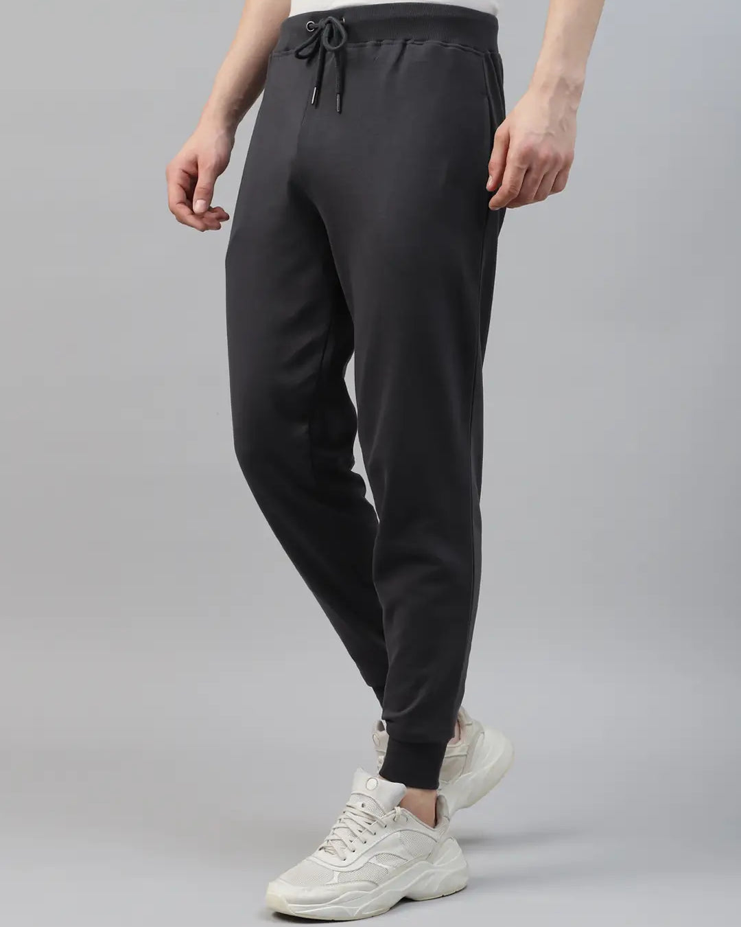 Person wearing black jogger pants and white sneakers