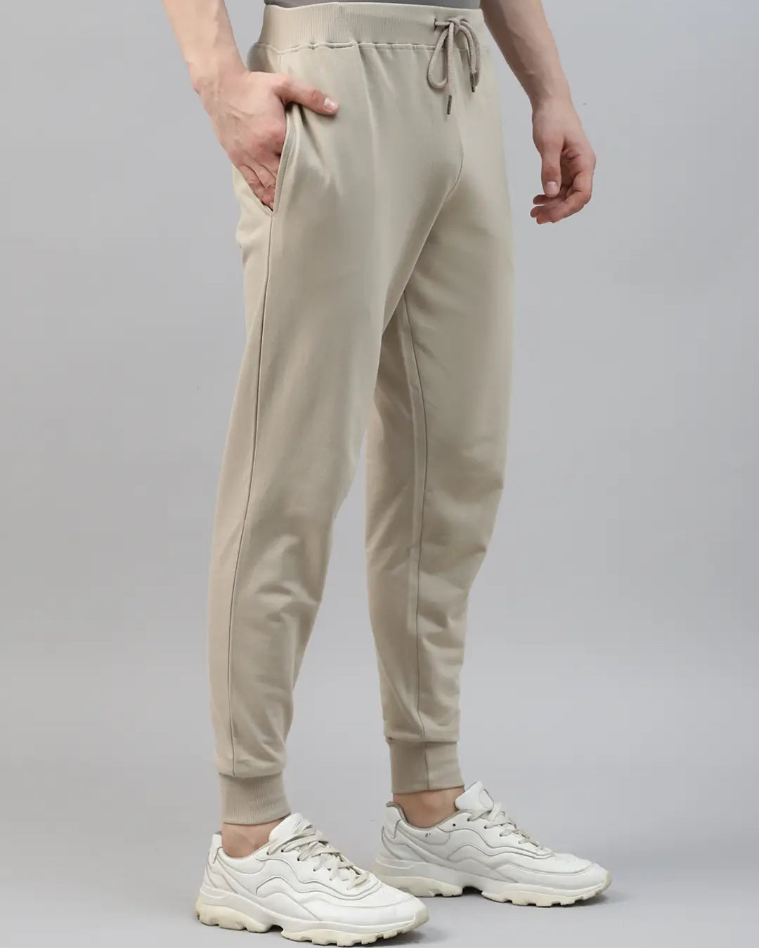 Person wearing beige jogger pants and white sneakers