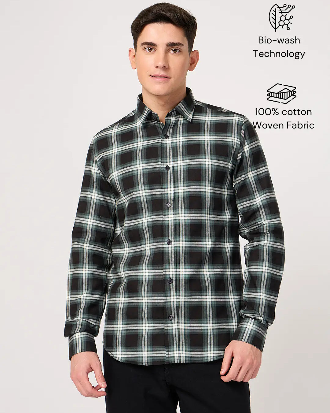 Man wearing a black and green plaid shirt made with pure cotton fabric