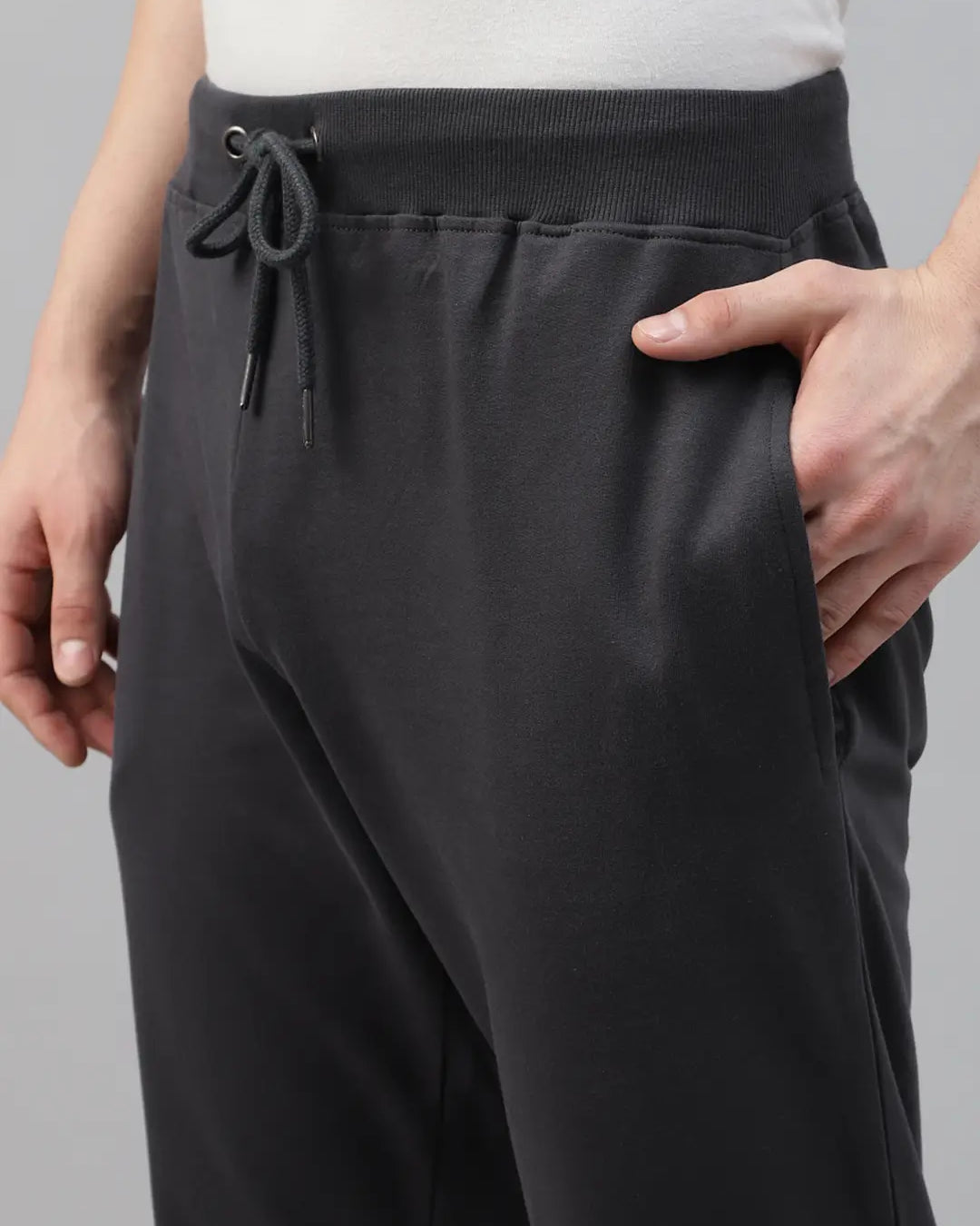 Person wearing dark grey jogger pants with a drawstring
