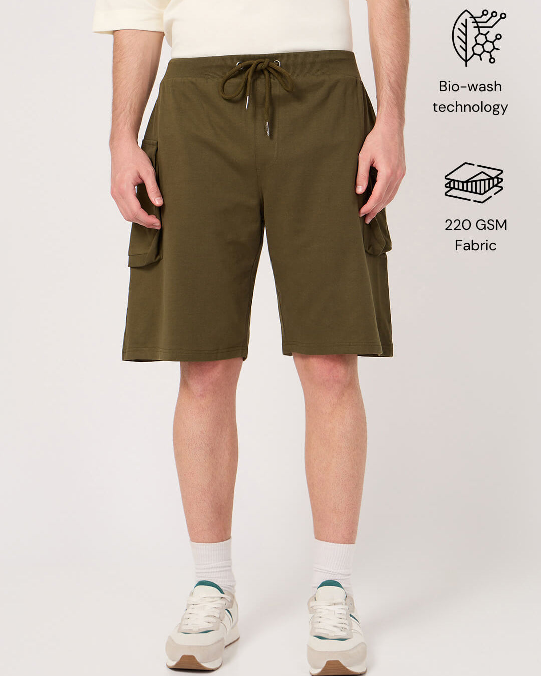 Person wearing olive green shorts on a white background