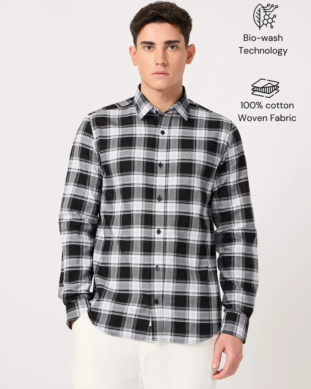 Man wearing a black and white plaid shirt with text about bio-wash technology and 100% cotton fabric on a white background.