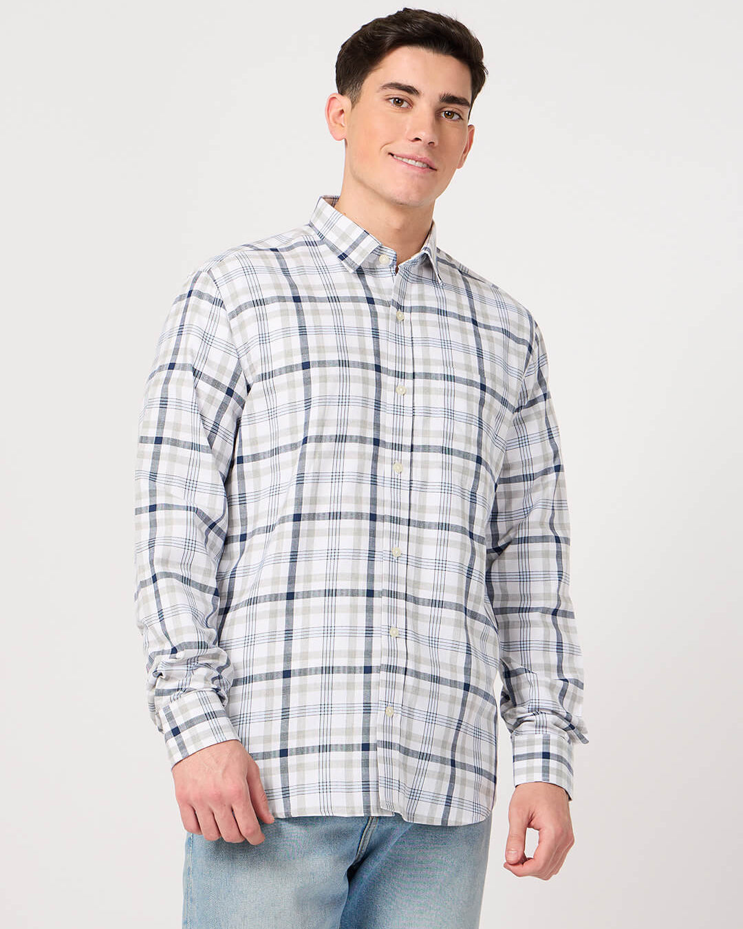 Man wearing a cotton check shirt and jeans on a white background