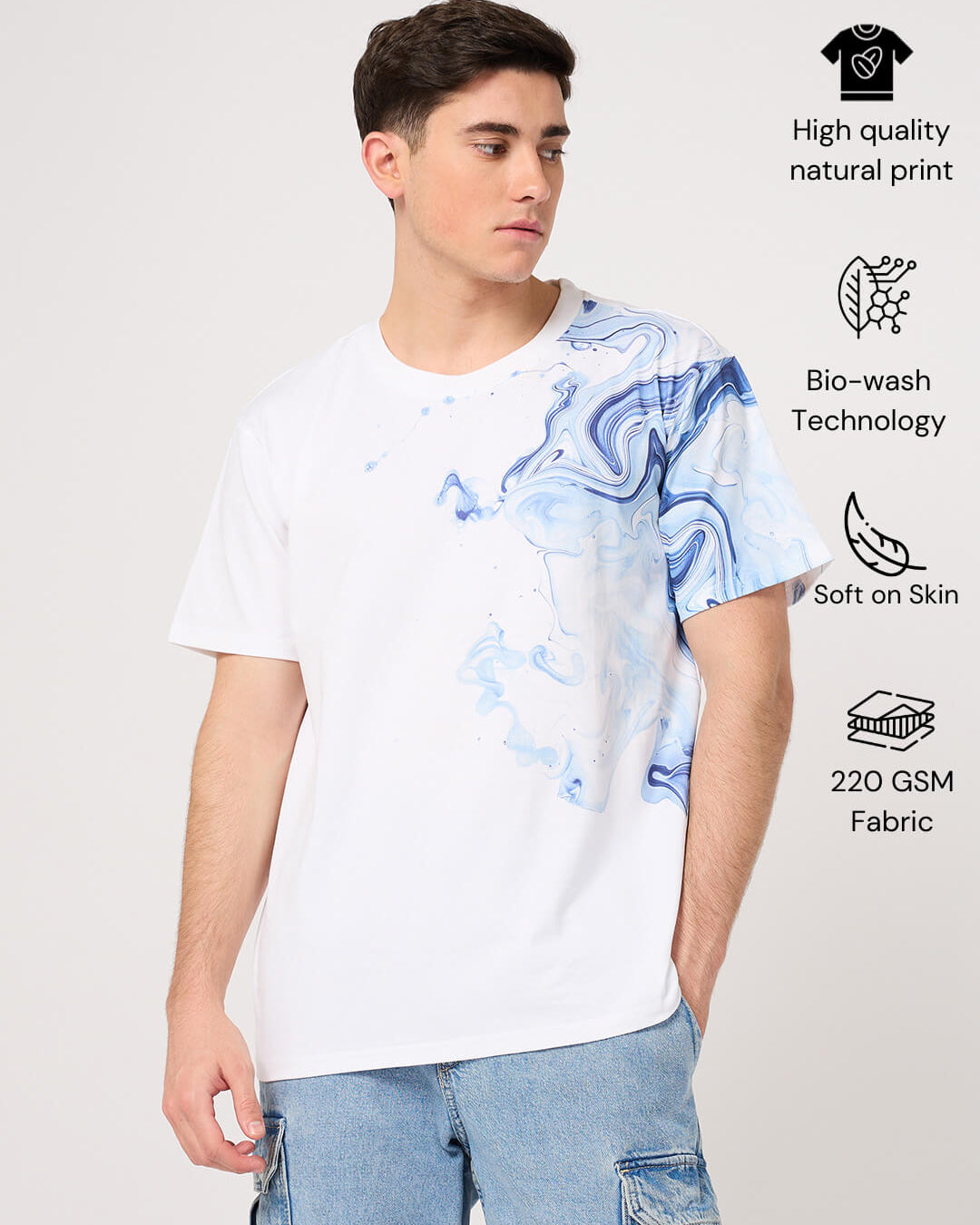 Person wearing a white t-shirt with blue abstract design on a light gray background