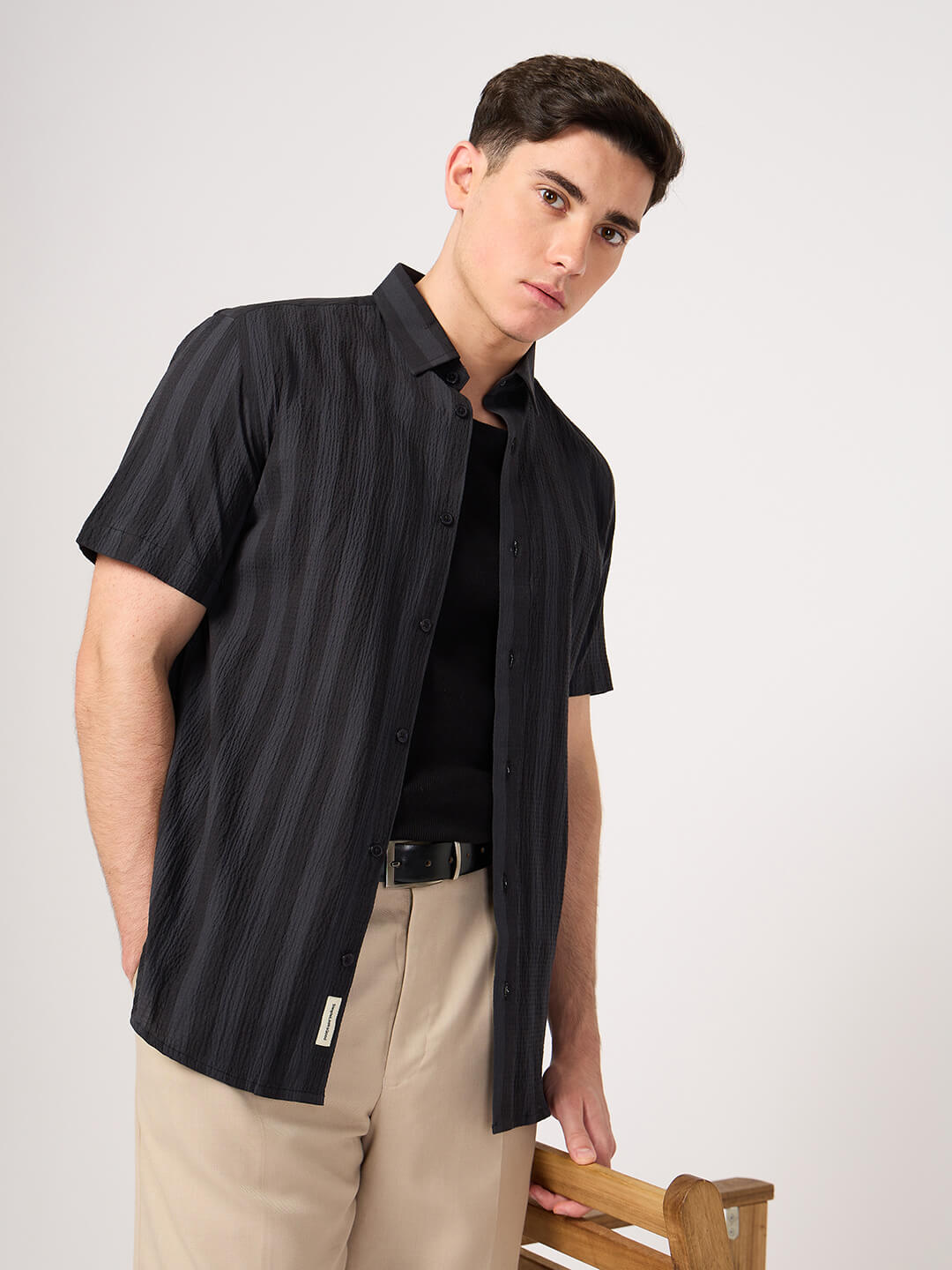 A man wearing a striped half sleeve shirt.