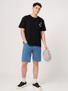 man wering a black printed t shirt with shorts