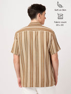 Man wearing a brown and beige striped shirt on a white background