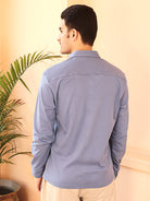 A man wearing a grey knit cotton shirt and beige pants