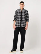 Man wearing a black and white checkered shirt and black pants