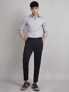 Man wearing a light gray shirt and black pants