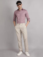 Man wearing a shirt, beige pants, and white sneakers on a gray background