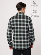 Man wearing a black and green plaid shirt