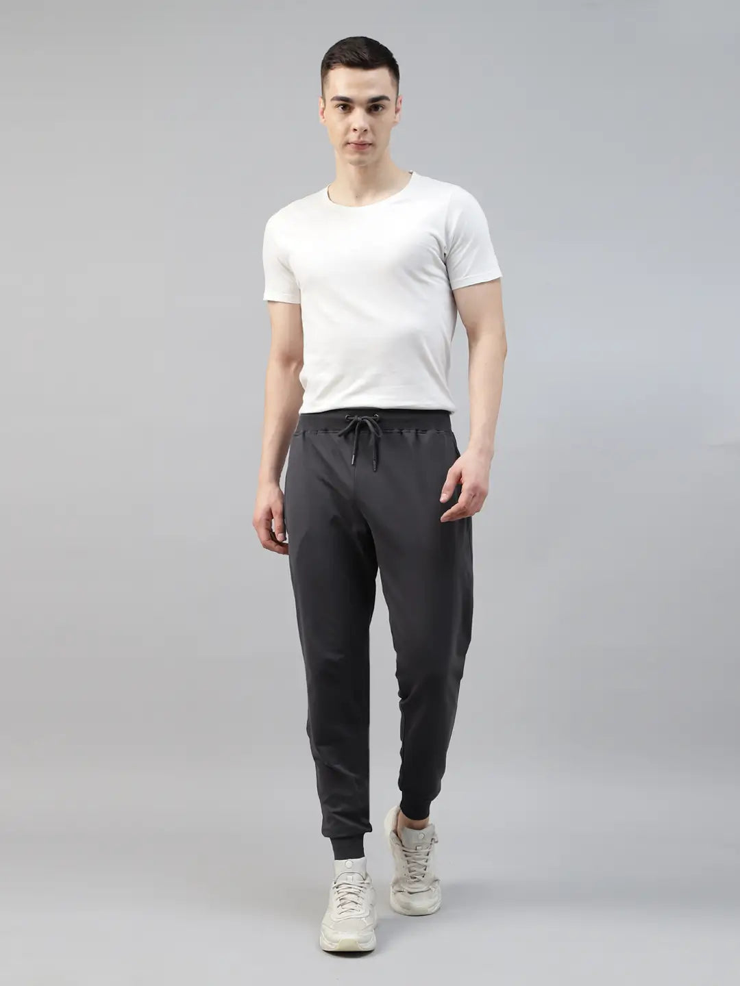 Man wearing a white t-shirt and dark gray jogger pants