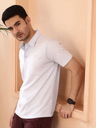 Man wearing a white polo shirt and maroon pant