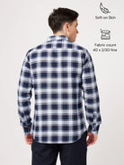 Man wearing a blue and white checkered shirt with fabric details on a white background