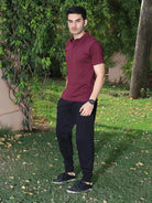 Man wearing a maroon polo shirt and black pants