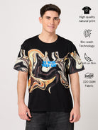 Man wearing a black t-shirt with printed abstract design on a light gray background.