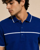 man wearing a royal blue polo shirt with white contrast piping