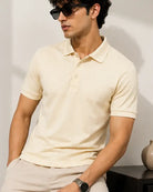 A man wearing a cream polo t shirt