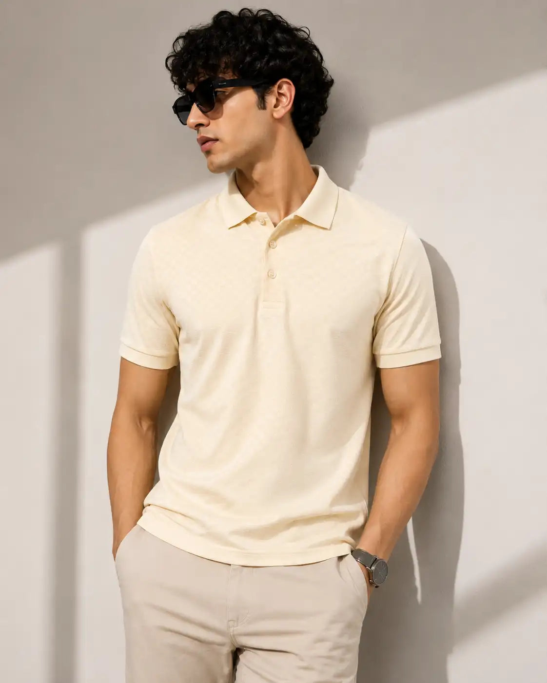 A man wearing a light cream short-sleeve polo shirt