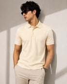 A man wearing a light cream short-sleeve polo shirt