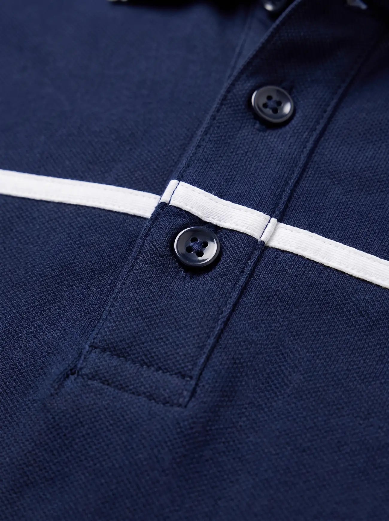Close-up of a navy blue polo shirt with a white horizontal stripe across the chest
