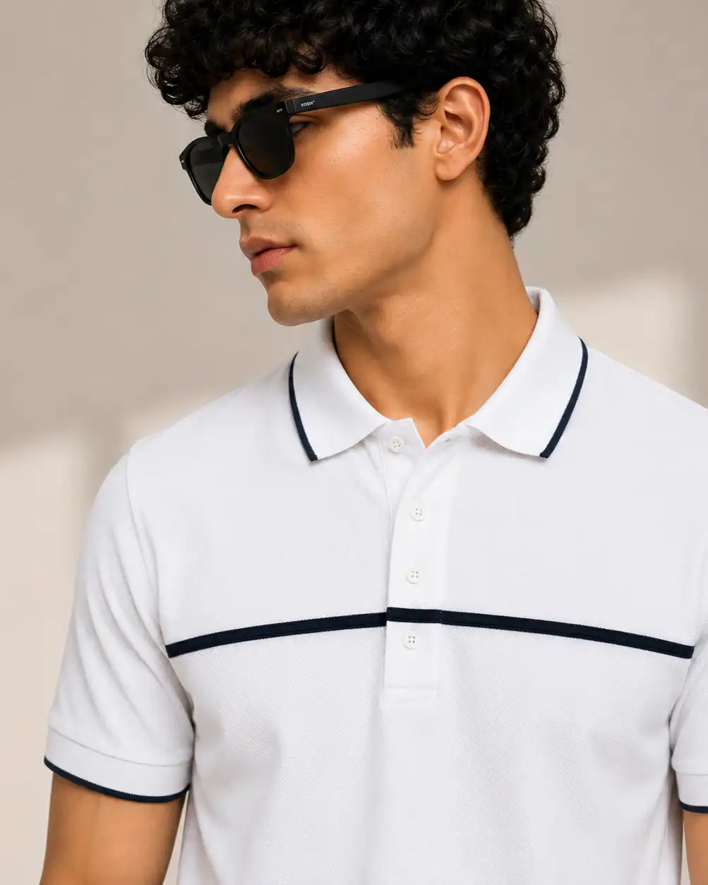 A man wearing a white short-sleeve polo shirt