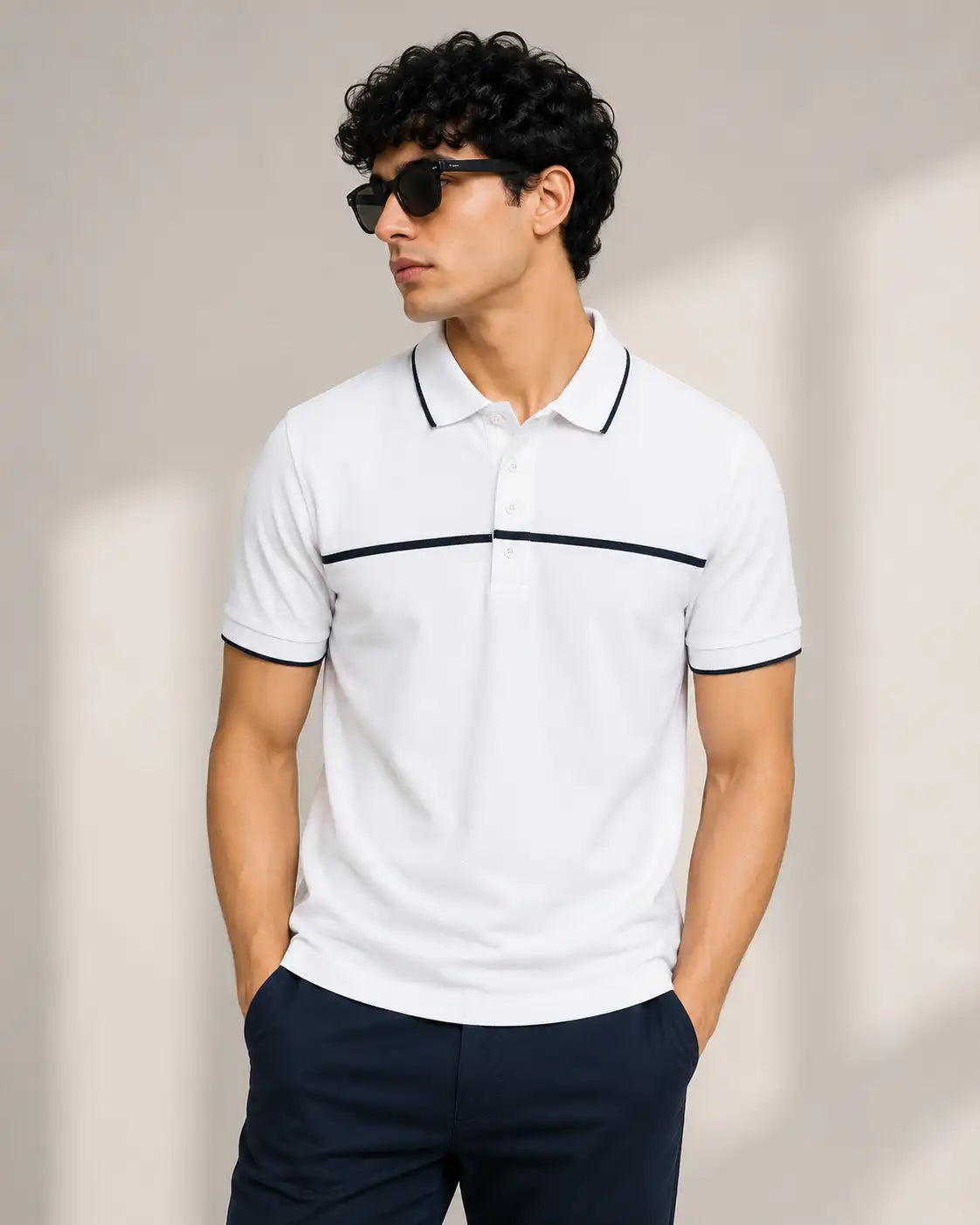 A man wearing a white short-sleeve polo tshirt with thin black chest stripe