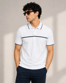 A man wearing a white short-sleeve polo tshirt with thin black chest stripe